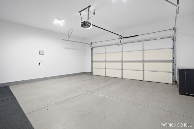garage featuring a garage door opener and baseboards