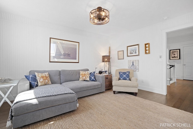 living room with wood finished floors, a chandelier, and baseboards