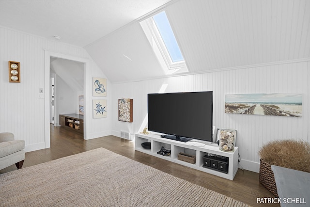 living room featuring a skylight, wood finished floors, baseboards, and vaulted ceiling