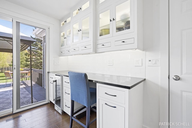office featuring wine cooler, dark wood-type flooring, and built in desk