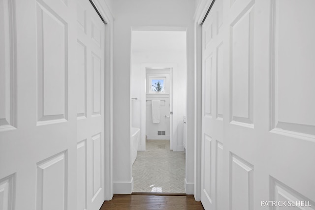 corridor featuring dark wood-style floors and baseboards