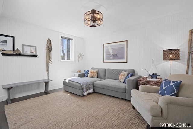 living room featuring baseboards, a chandelier, and wood finished floors