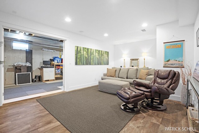 living room with wood finished floors, baseboards, and recessed lighting
