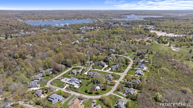 aerial view of property's location with a large body of water and a forest