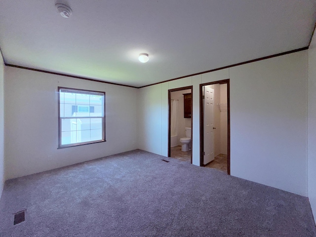unfurnished bedroom featuring ornamental molding, carpet, and ensuite bathroom