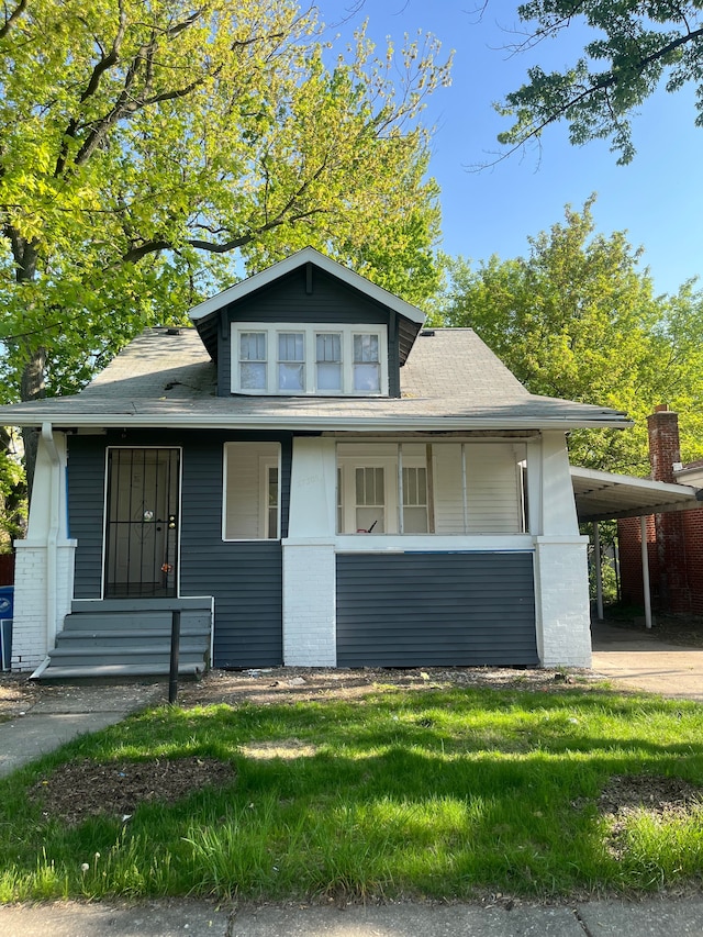 27305 Norfolk St, Inkster, MI 48141 - bungalow-style house with brick siding, a carport, a front lawn, a shingled roof, and a porch