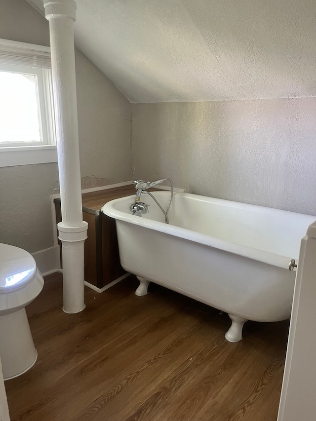 27305 Norfolk St, Inkster, MI 48141 - bathroom with wood finished floors, lofted ceiling, a freestanding tub, toilet, and a textured ceiling