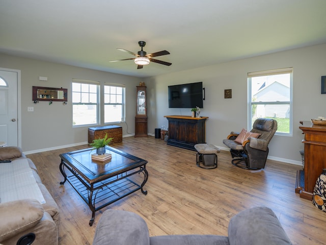 living room featuring healthy amount of natural light, ceiling fan, wood finished floors, and baseboards