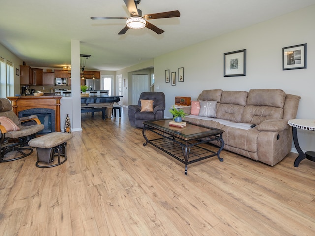 living area with light wood-style floors, plenty of natural light, and ceiling fan
