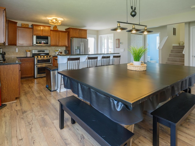 dining area featuring stairway and light wood-type flooring