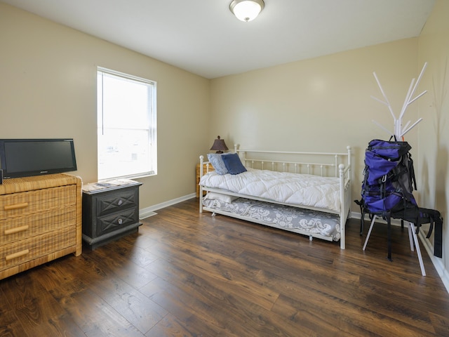 bedroom featuring wood finished floors and baseboards