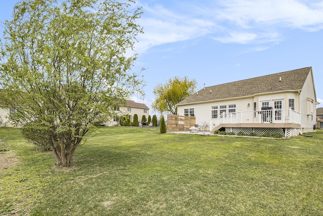 back of property with a deck and a lawn
