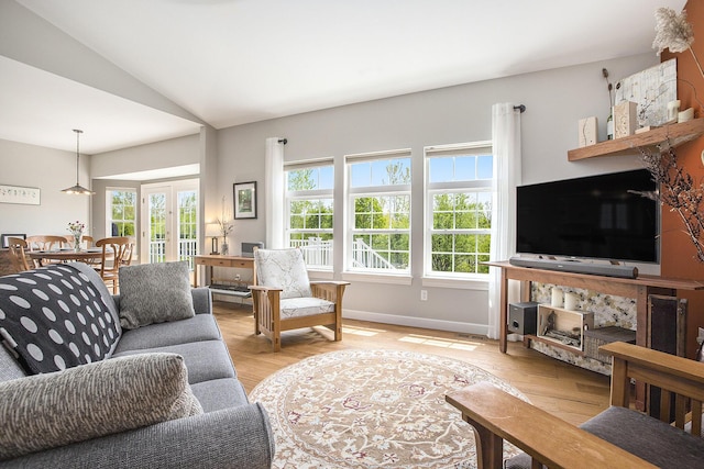 living area with light wood-style flooring, vaulted ceiling, and baseboards