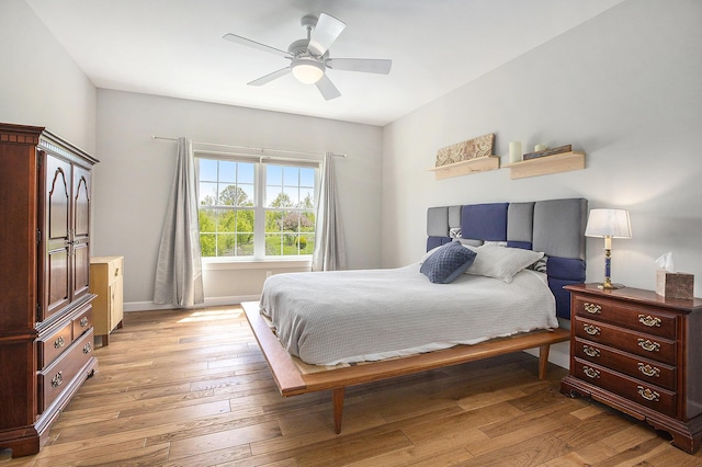 bedroom featuring light wood-style floors, baseboards, and ceiling fan