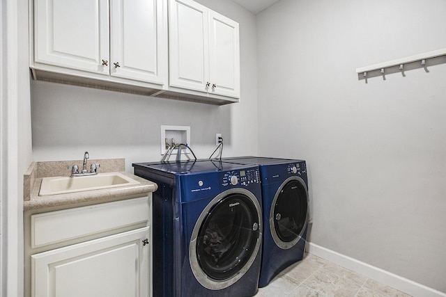 laundry room featuring cabinet space, separate washer and dryer, and baseboards