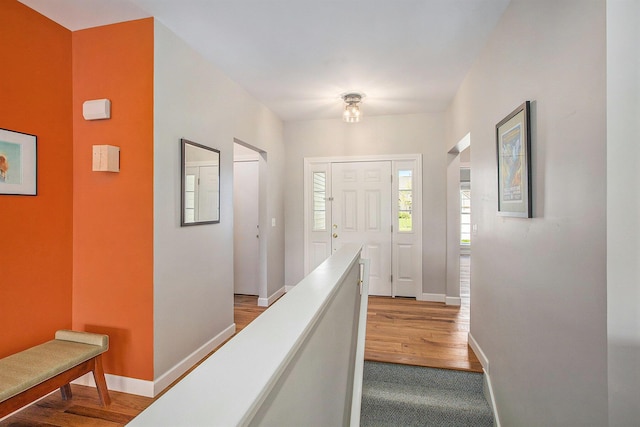 corridor featuring wood finished floors and baseboards