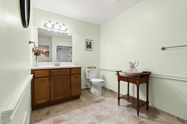 bathroom with toilet, vanity, and a shower