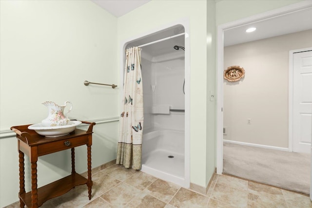 bathroom with a stall shower, baseboards, and recessed lighting