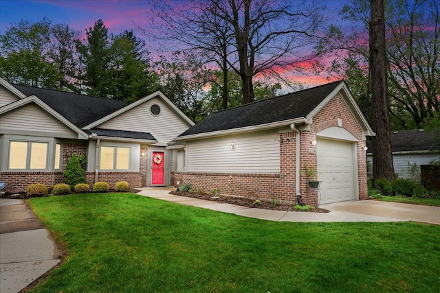 view of front facade featuring brick siding, driveway, a lawn, and an attached garage
