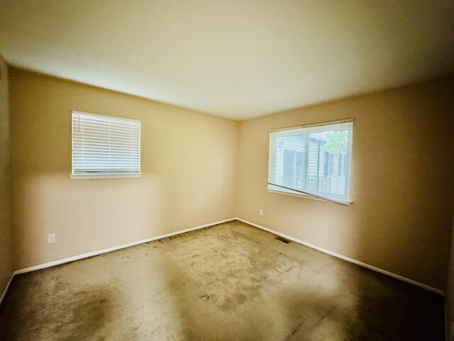 carpeted spare room with baseboards