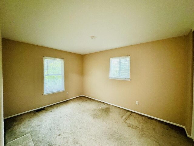 empty room with baseboards and carpet floors