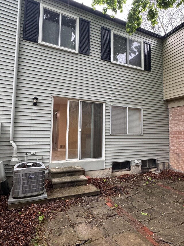 rear view of property featuring entry steps, central AC unit, and a patio