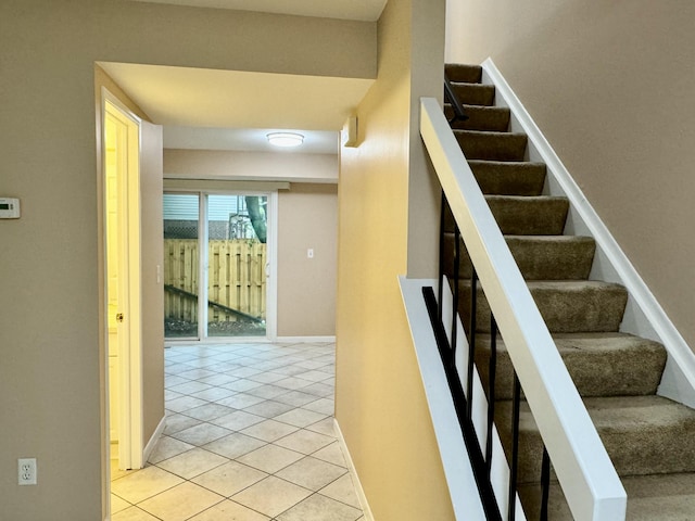 stairs featuring tile patterned floors and baseboards