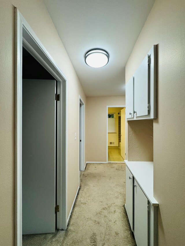 corridor with light carpet and baseboards