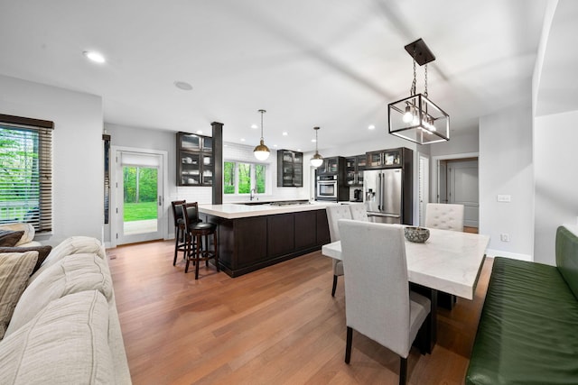dining space featuring light wood finished floors, recessed lighting, a chandelier, and baseboards