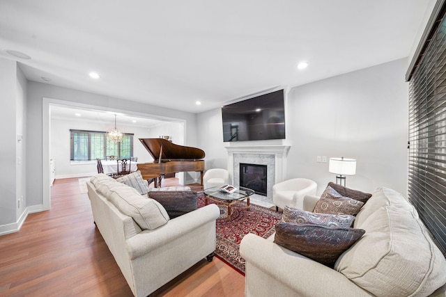 living area with wood finished floors, a chandelier, a fireplace, recessed lighting, and baseboards