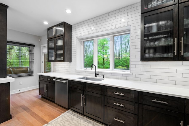 kitchen with a sink, stainless steel dishwasher, healthy amount of natural light, tasteful backsplash, and recessed lighting