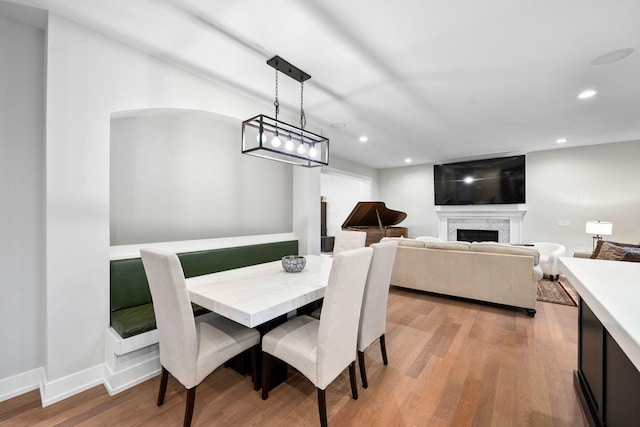 dining space with light wood-style floors, recessed lighting, a fireplace, and baseboards