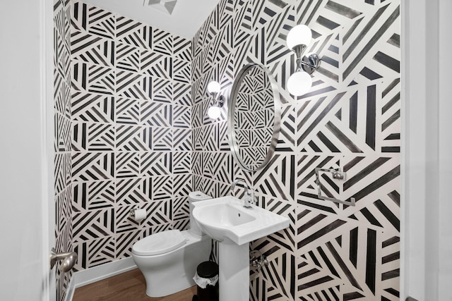 half bath with toilet and wood finished floors