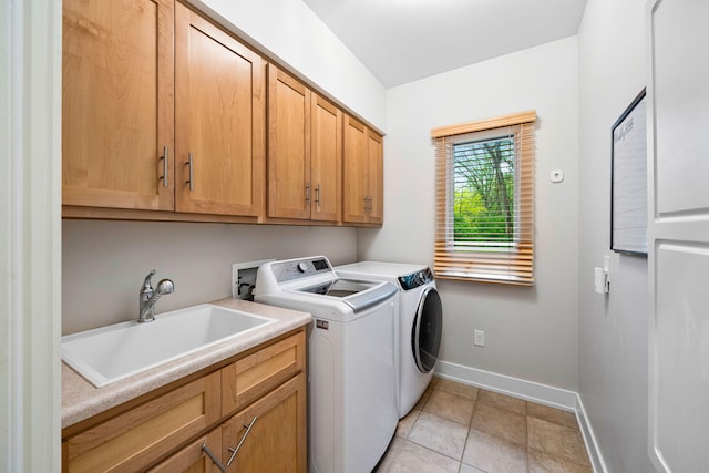 laundry room with cabinet space, washer and clothes dryer, baseboards, and light tile patterned floors