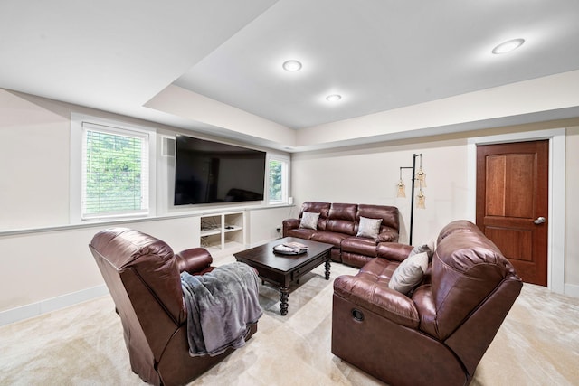 living area with light carpet, healthy amount of natural light, and baseboards