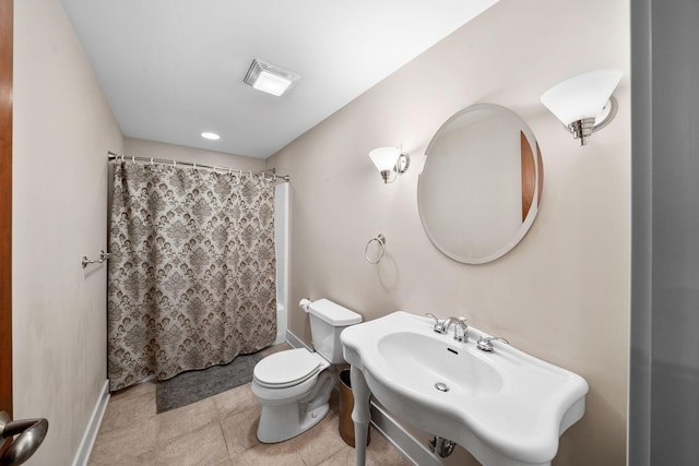 full bathroom with toilet, curtained shower, baseboards, and a sink