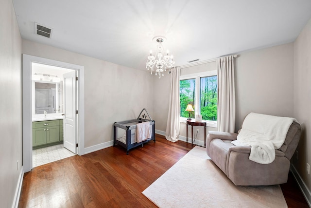 sitting room with wood finished floors, a chandelier, and baseboards