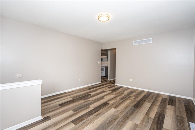 spare room with wood finished floors and baseboards
