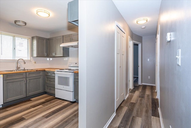 kitchen with white electric stove, gray cabinetry, butcher block counters, under cabinet range hood, and a sink