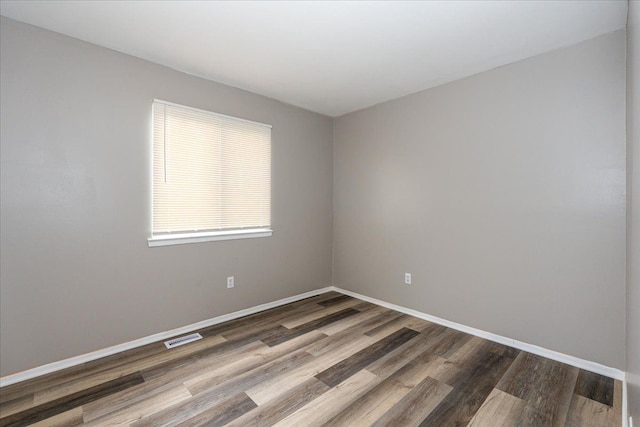 unfurnished room featuring wood finished floors and baseboards