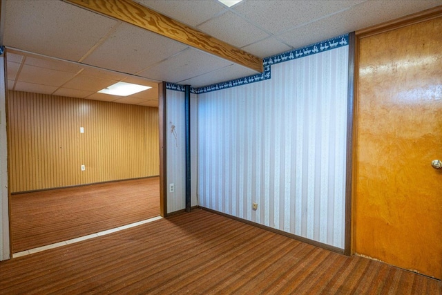 spare room with a paneled ceiling, carpet flooring, and baseboards