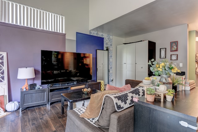 living room with dark wood finished floors and a towering ceiling