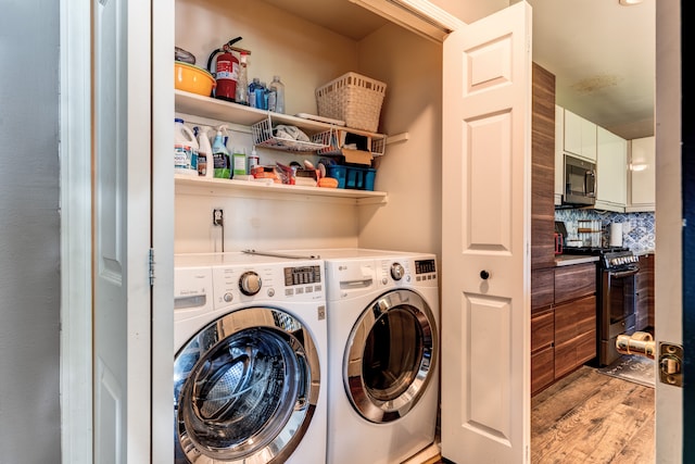 laundry room featuring washing machine and clothes dryer and light wood-type flooring