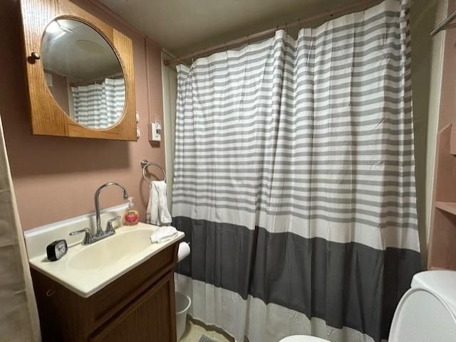 full bath with toilet, vanity, and a shower with curtain