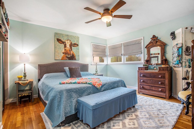 bedroom featuring wood finished floors, baseboards, and a ceiling fan