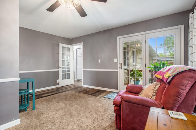 living area with baseboards, ceiling fan, wood finished floors, and french doors
