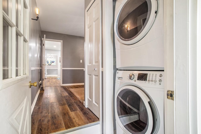 laundry area featuring stacked washer / drying machine and dark wood finished floors