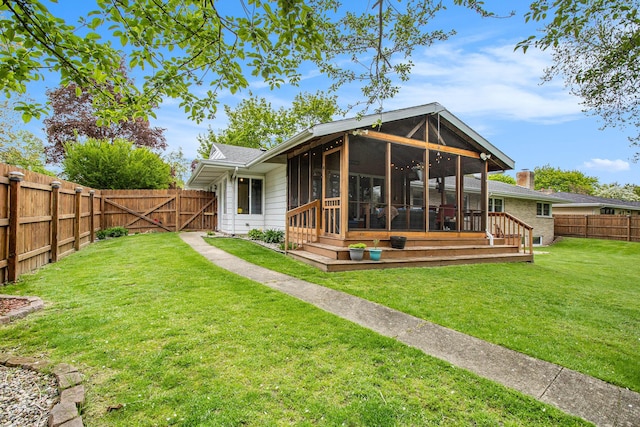 rear view of property with a sunroom and a gate