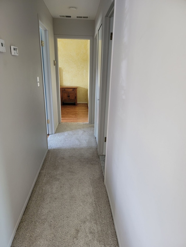 hall with light carpet and baseboards