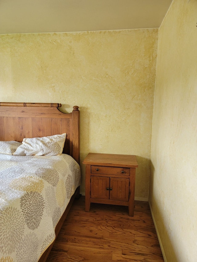 bedroom with wood finished floors and baseboards